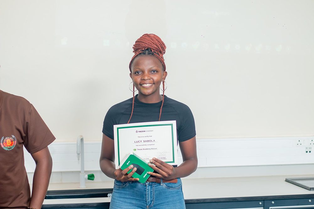 Bitcoin Boma participants receiving Trezor hardware wallets and certificates at UNIMA Bitcoin Education Program March 2026