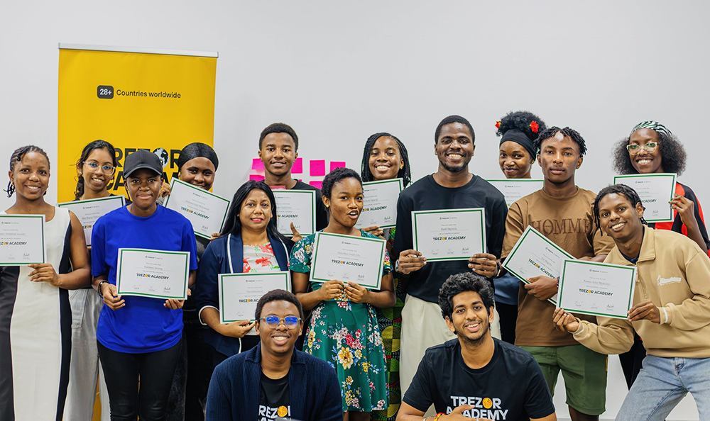 Trezor Academy graduates in Mauritius holding completion certificates after Bitcoin education sessions.