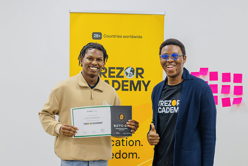 Trezor Academy graduates in Mauritius holding completion certificates after Bitcoin education sessions.
